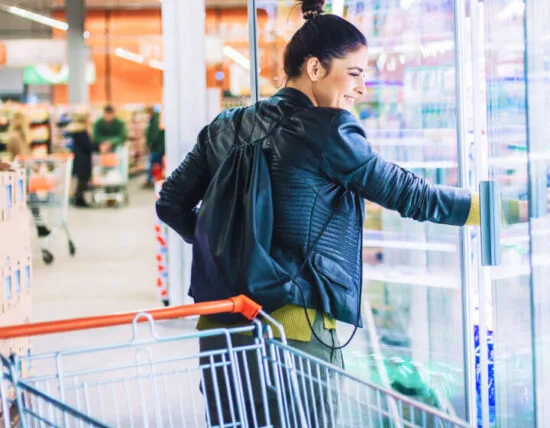 Vrouw pakt product uit het zuivelschap