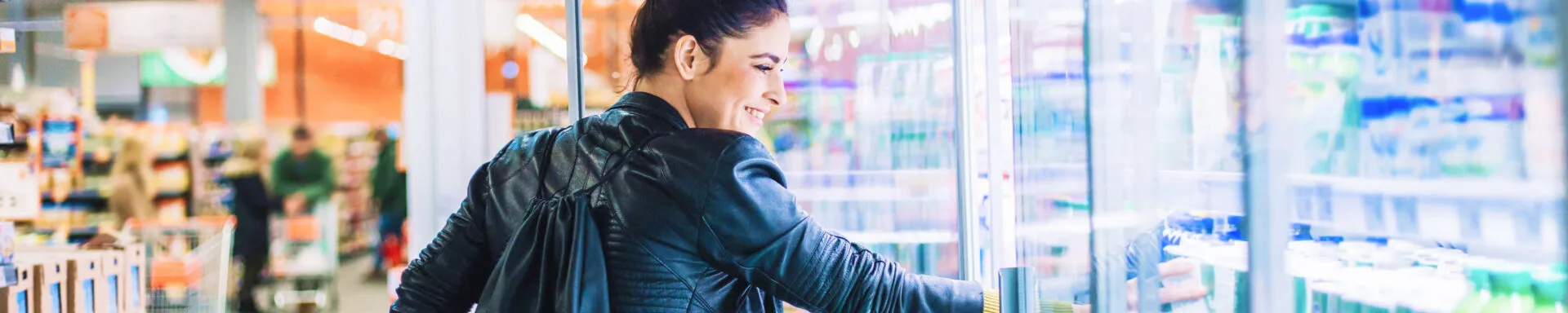 Vrouw pakt product uit het zuivelschap
