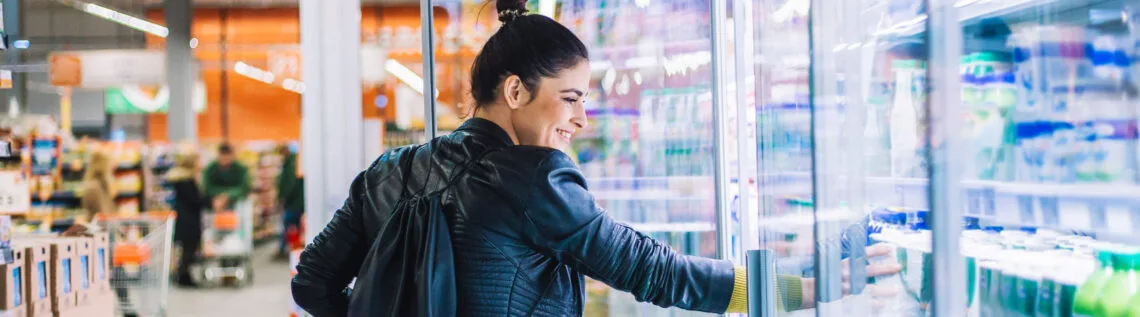 Vrouw pakt product uit het zuivelschap