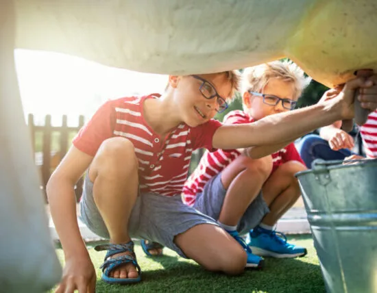 Kinderen melken koeien tijdens de boerderij excursie